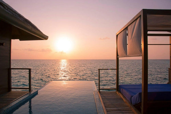 Sunset from a villa deck at Coco Bodu Hithi in North Malé Atoll, the sun's track reflected down the length of the pool
