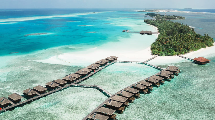 The overwater villa jetty at Medhufushi Island Resort from the air, over the lagoon.