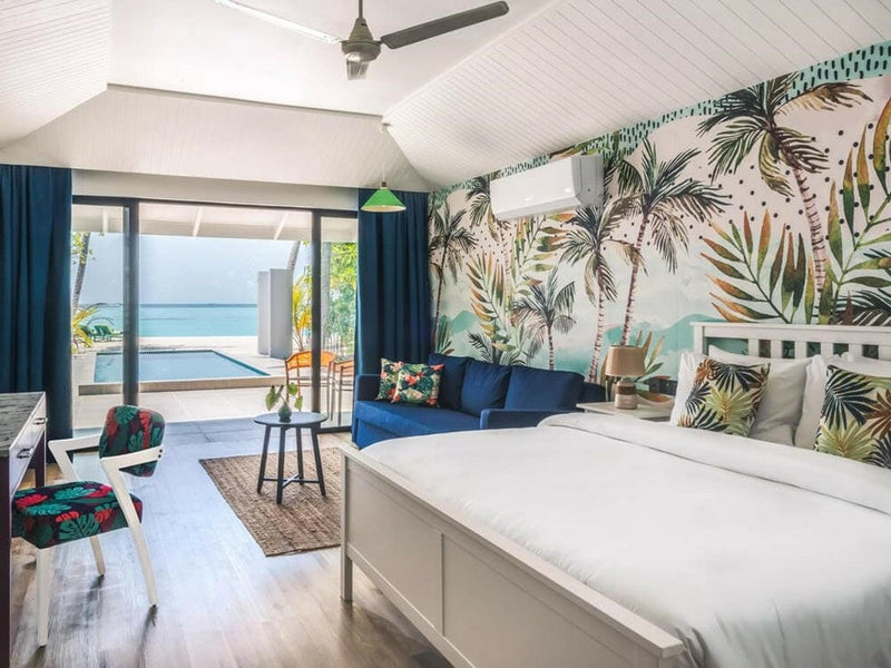 A pool villa bedroom at Villa Park Sun Island, leaf print walls and doors open to the pool terrace