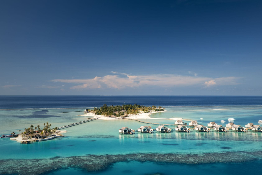 The island and its row of overwater villas across the lagoon at RAH GILI Maldives.