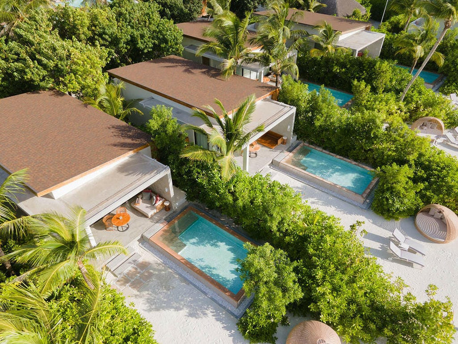 Kuda Villingili from above, beach villas with private pools set among dense palms.