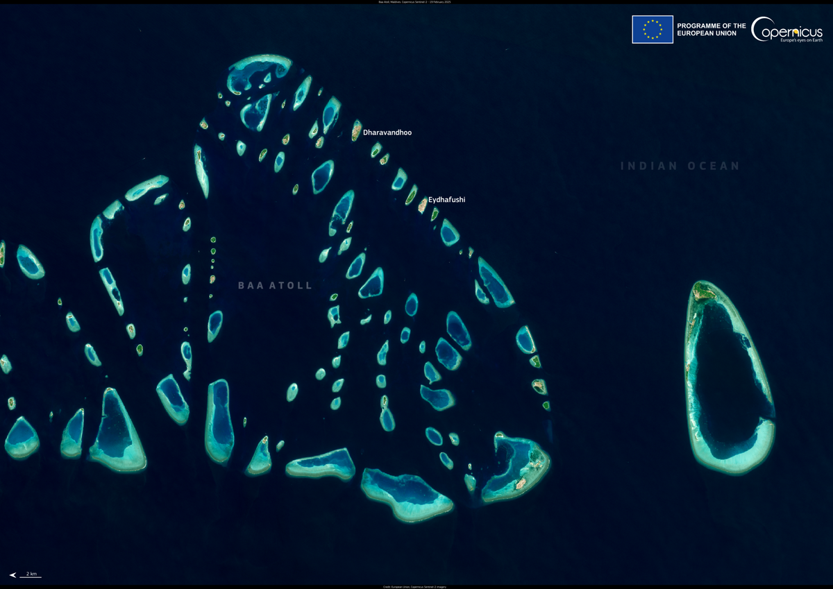 Baa Atoll seen from space, a ring of reefs and small islands in deep blue water