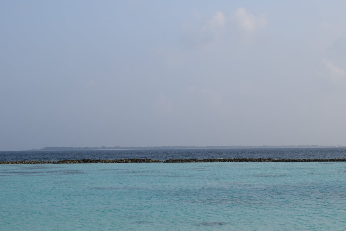The long, low island of Dhigurah seen across the water of South Ari Atoll