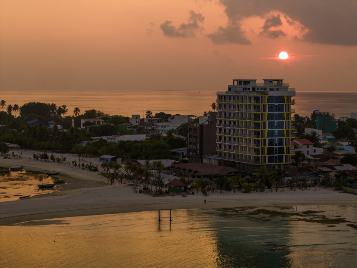 The beach and hotel buildings of Guraidhoo at sunset, seen from the air