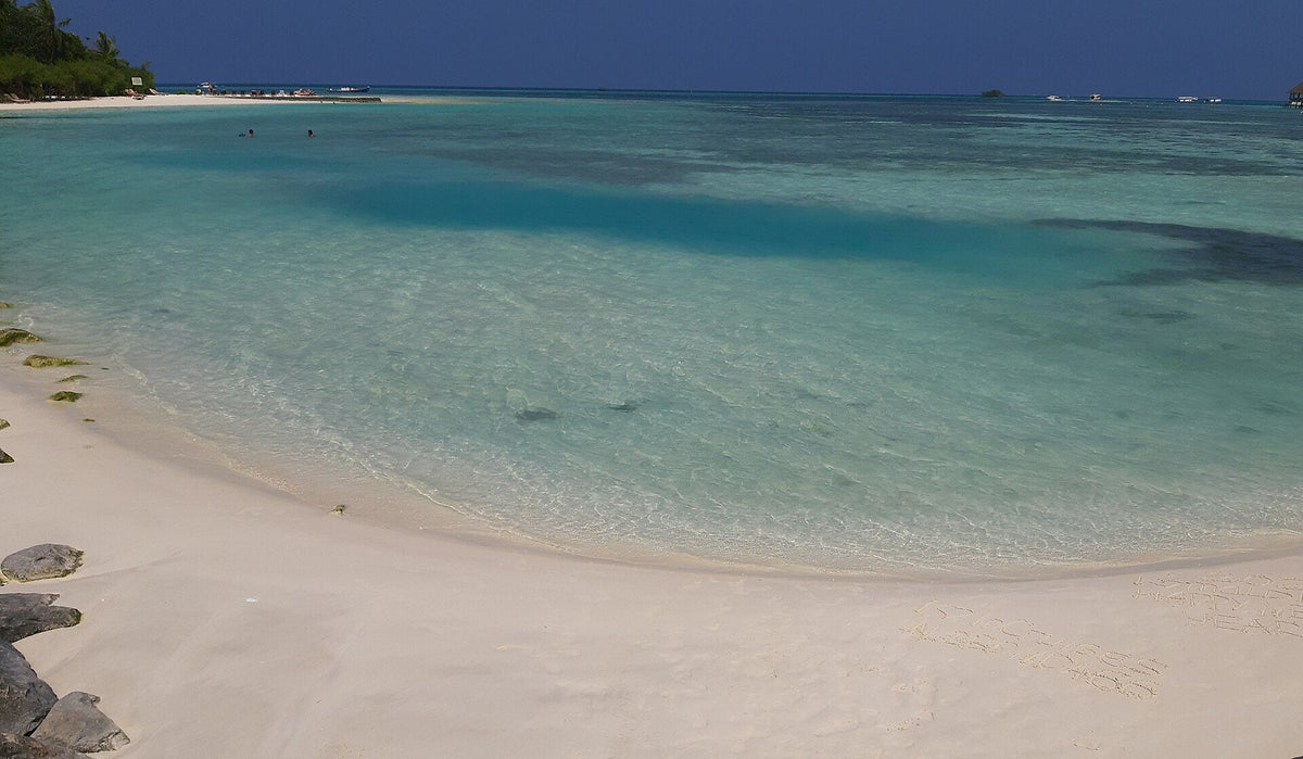 A curve of white sand and a clear turquoise lagoon on Huraa, North Malé Atoll