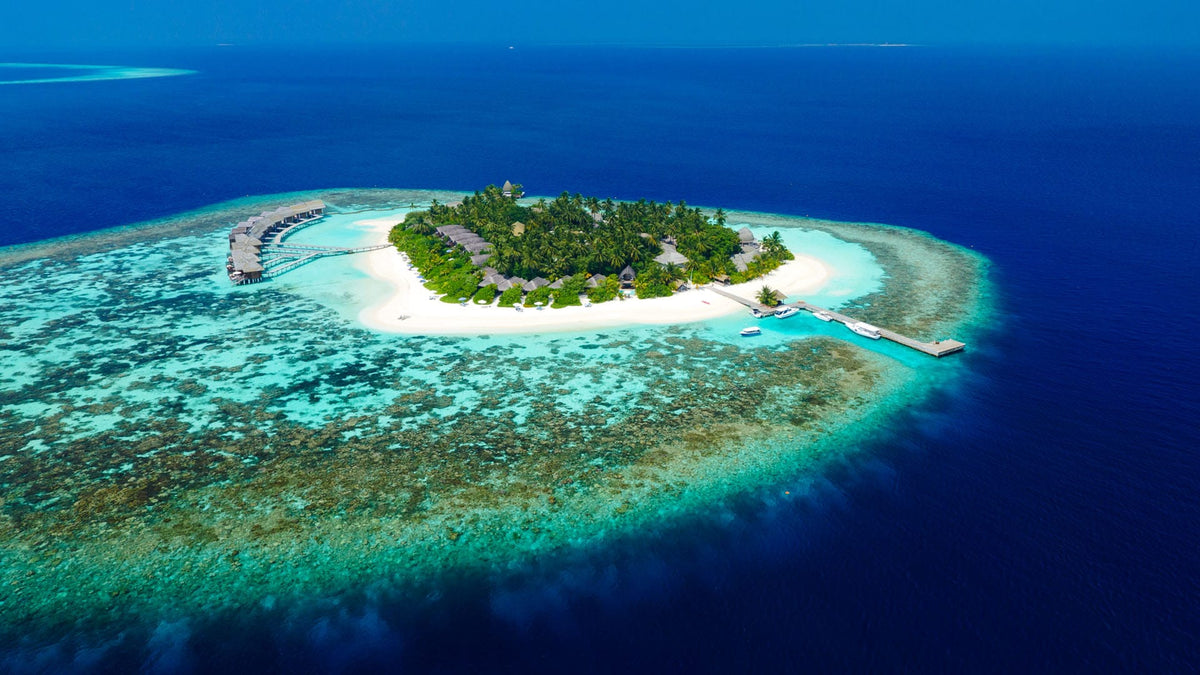 Kandolhu Maldives from the air, the small round island inside its reef.
