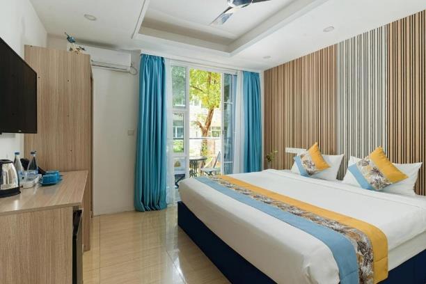 h78 Iru Hulhumalé, North Malé Atoll: Superior Double Room with a king bed, a slatted wood wall and glass doors to a balcony