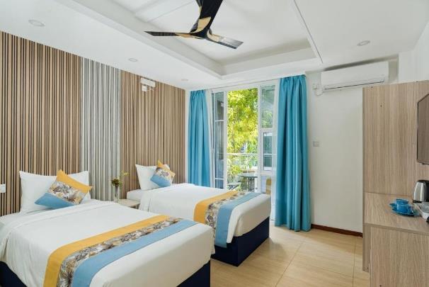 h78 Iru Hulhumalé, North Malé Atoll: Superior Twin Room with two beds, blue curtains and glass doors to a balcony over the trees
