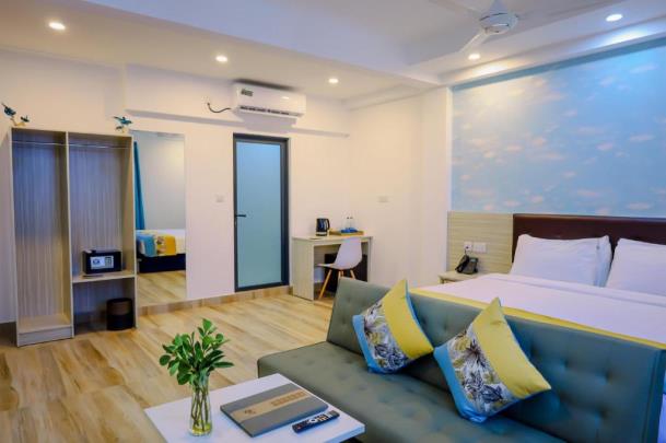 h78 Iru Hulhumalé, North Malé Atoll: Junior Suite with a double bed, a blue sofa, a desk and a sky-painted feature wall