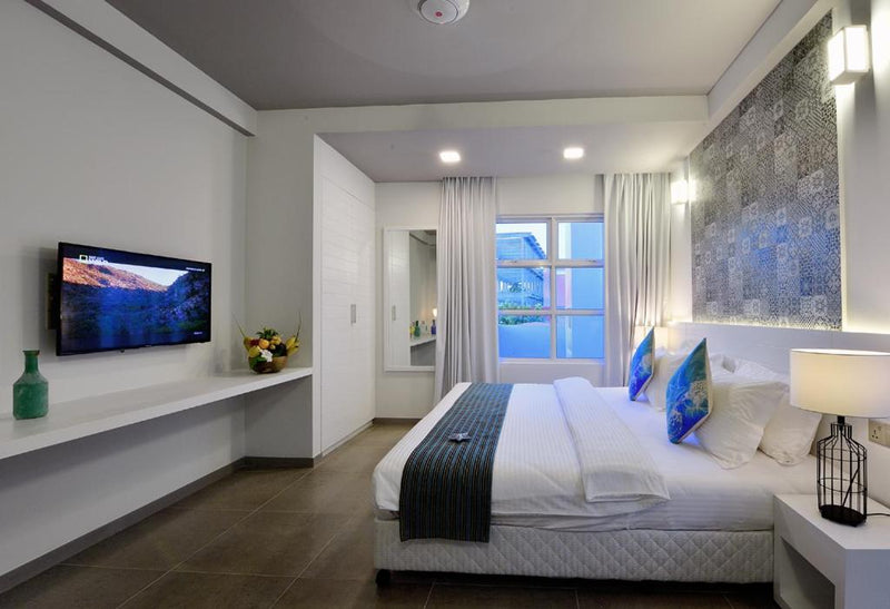Double room at Velana Beach Hotel with a wall-mounted TV and desk