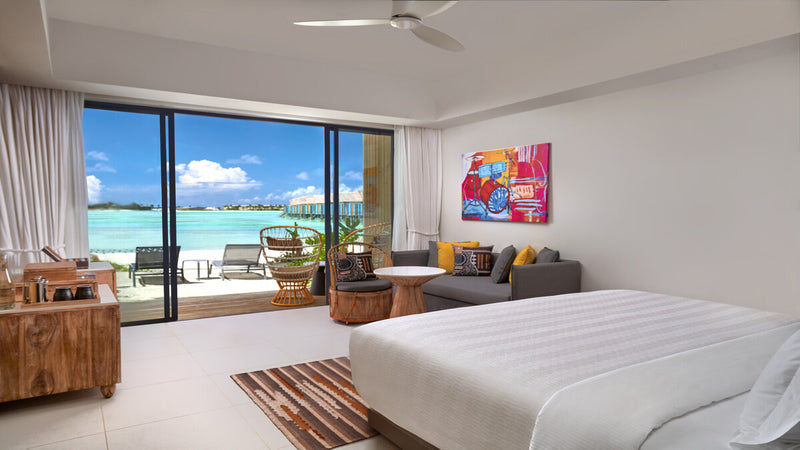 A Silver Beach Studio at Hard Rock Hotel Maldives, pop art above the bed and a terrace onto the lagoon.