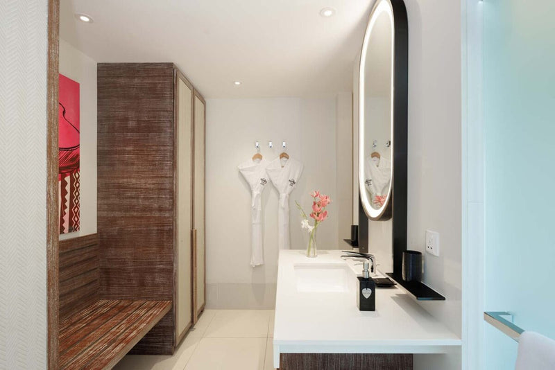 Another villa bathroom at Hard Rock Hotel Maldives, robes hanging beside the vanity.