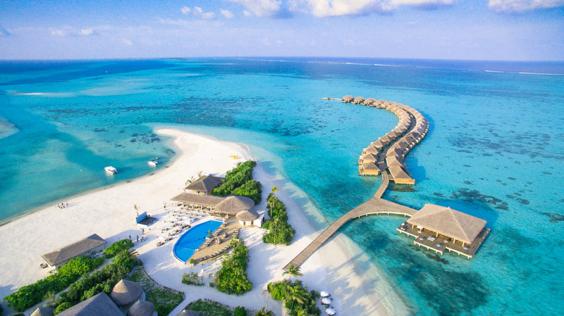 Cocoon Maldives from the air, the beach and the overwater villa row.