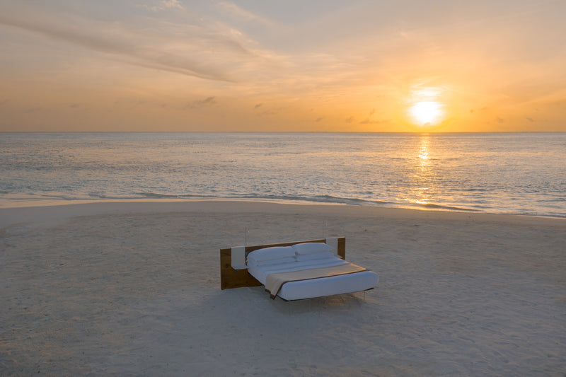 A lounger on the beach at sunset at Cocoon Maldives.