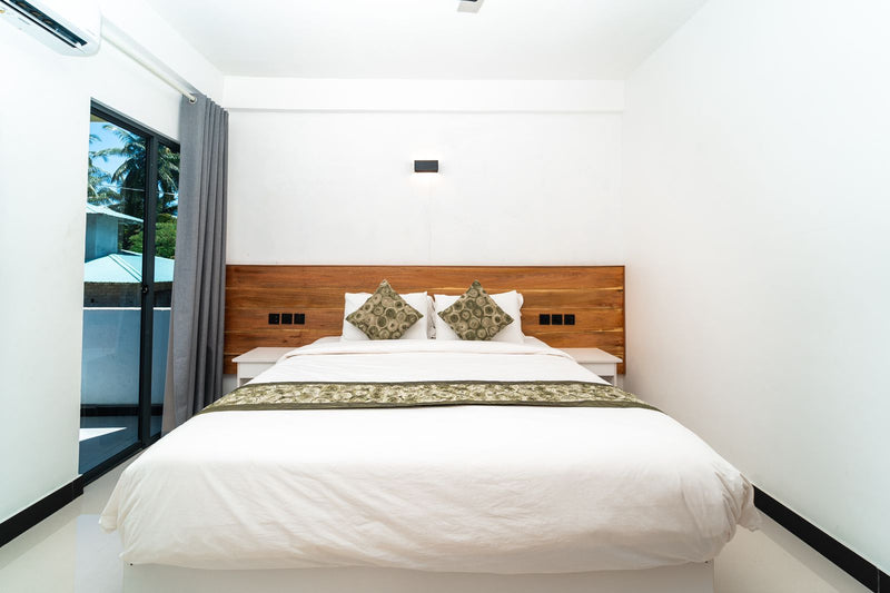 Double Bedroom at Cozy Roots Fuvahmulah with a timber headboard and a window