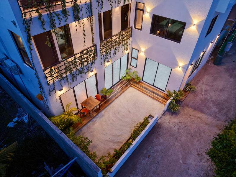 Courtyard at Cozy Art Dhangethi from above in the evening, with planters and lit balconies