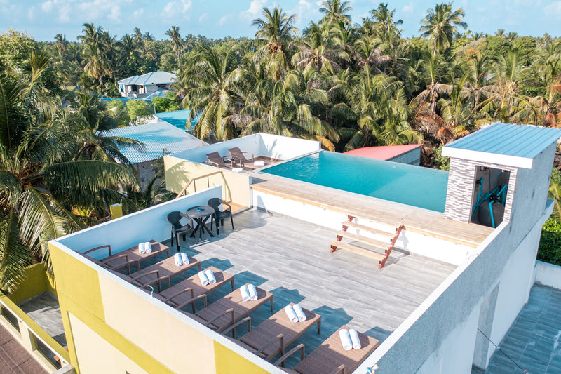 Rooftop deck at Cozy Roots Fuvahmulah with sun loungers lined up beside the pool