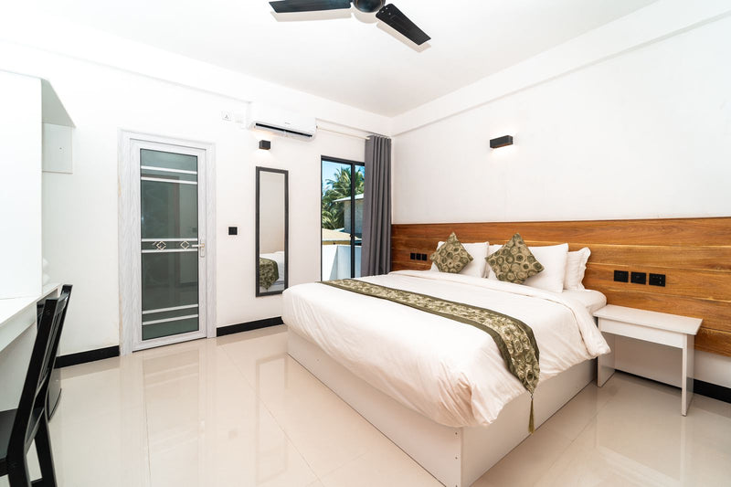 Double Bedroom at Cozy Roots Fuvahmulah with a ceiling fan and glass doors