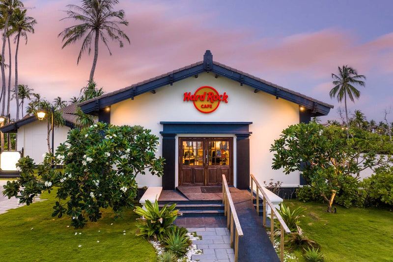The Hard Rock Cafe entrance at Hard Rock Hotel Maldives, framed by frangipani.