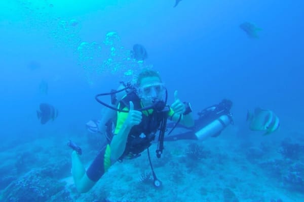 A diver over coral on one of the Meemu Atoll dive sites reached by boat from Medhufushi