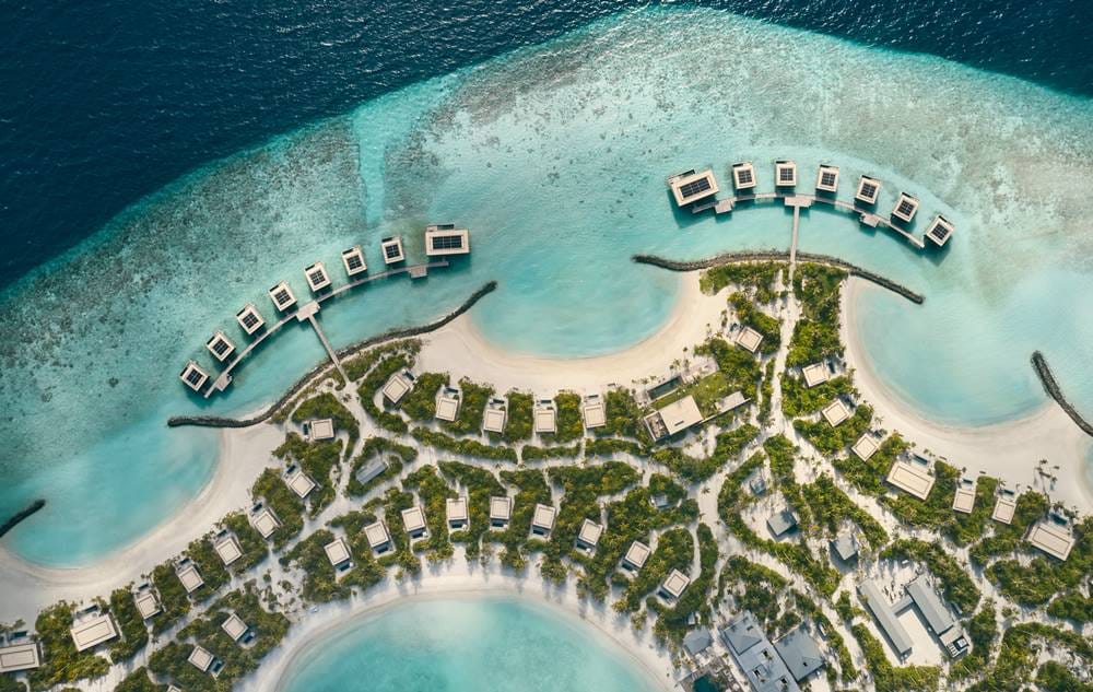 Patina Maldives, Fari Islands from the air, beach villas in landscaped grounds with the overwater villas curving off