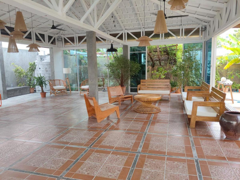 Open-sided lounge with wooden chairs at Rashu Hiyaa