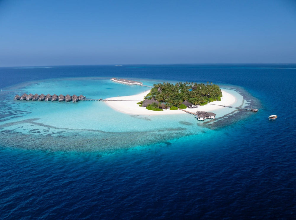 Angaga from the air in South Ari Atoll, reef on one side of the island and a pale shallow lagoon on the other