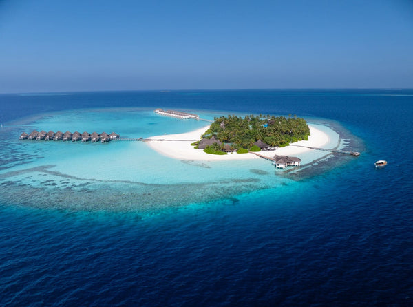Angaga from the air in South Ari Atoll, reef on one side of the island and a pale shallow lagoon on the other