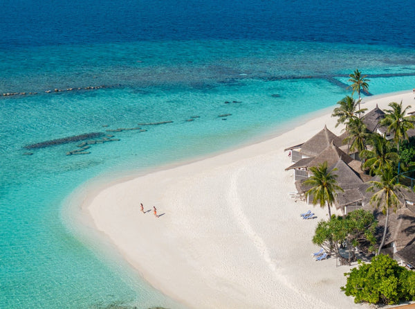 The beach at Angaga seen from above, with reef structure visible in the water a short way offshore