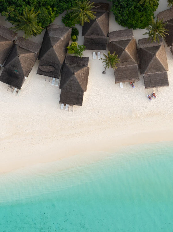 Thatched beach bungalows along the white sand at Angaga, seen from the air
