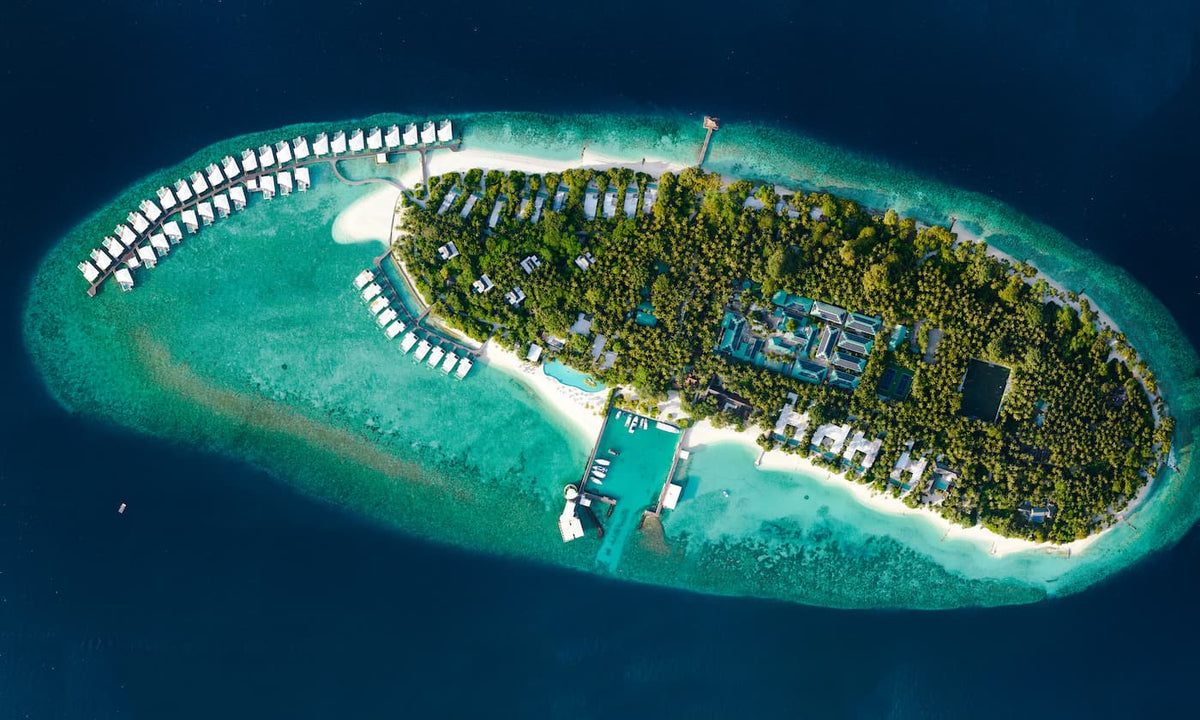 Amilla Maldives from the air, the overwater villas set out in a herringbone from the sand