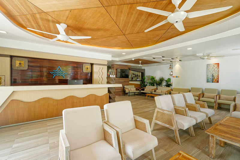 Lobby lounge at Arena Beach Hotel with white sofas and wooden ceiling