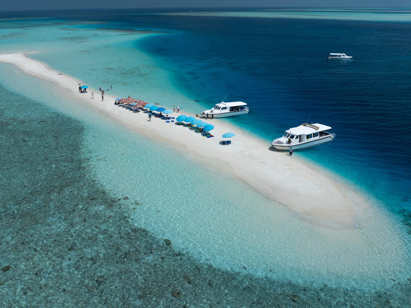 Aerial view of a sandbank with boats moored off it near Maafushi