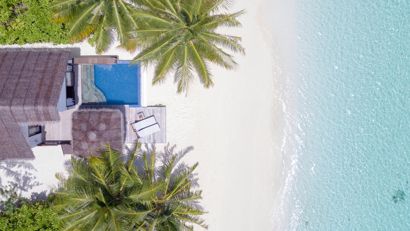 A Beach Pool Villa at Bandos Maldives seen from above, its pool beside the beach.