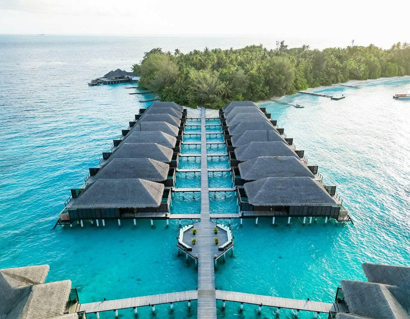 Coco Bodu Hithi from the air, twin rows of water villas running out along a jetty over the lagoon