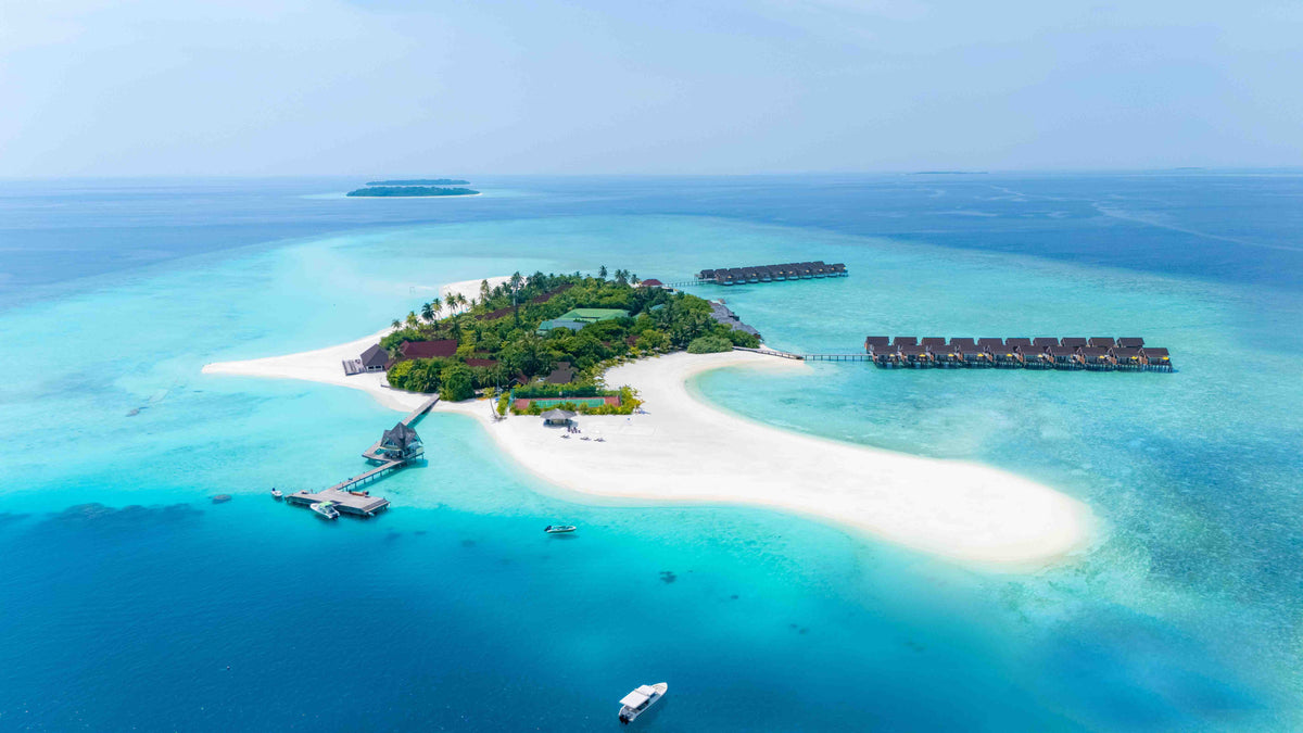 Dhigufaru Island Resort from the air, the island and its sandbank with overwater villas along one side
