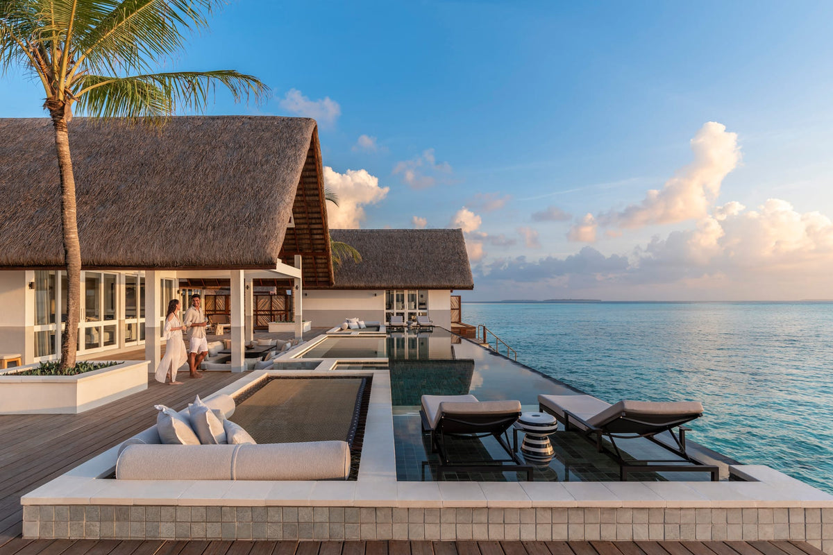 A villa terrace and pool at Four Seasons Resort Maldives at Landaa Giraavaru, looking out to sea at sunset