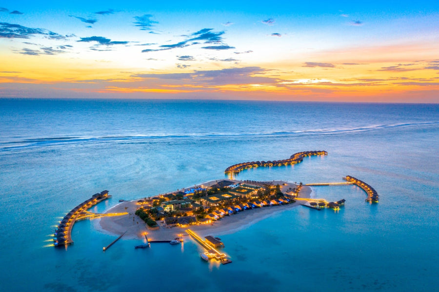 Aerial view of a Maldivian island fringed by shallow turquoise