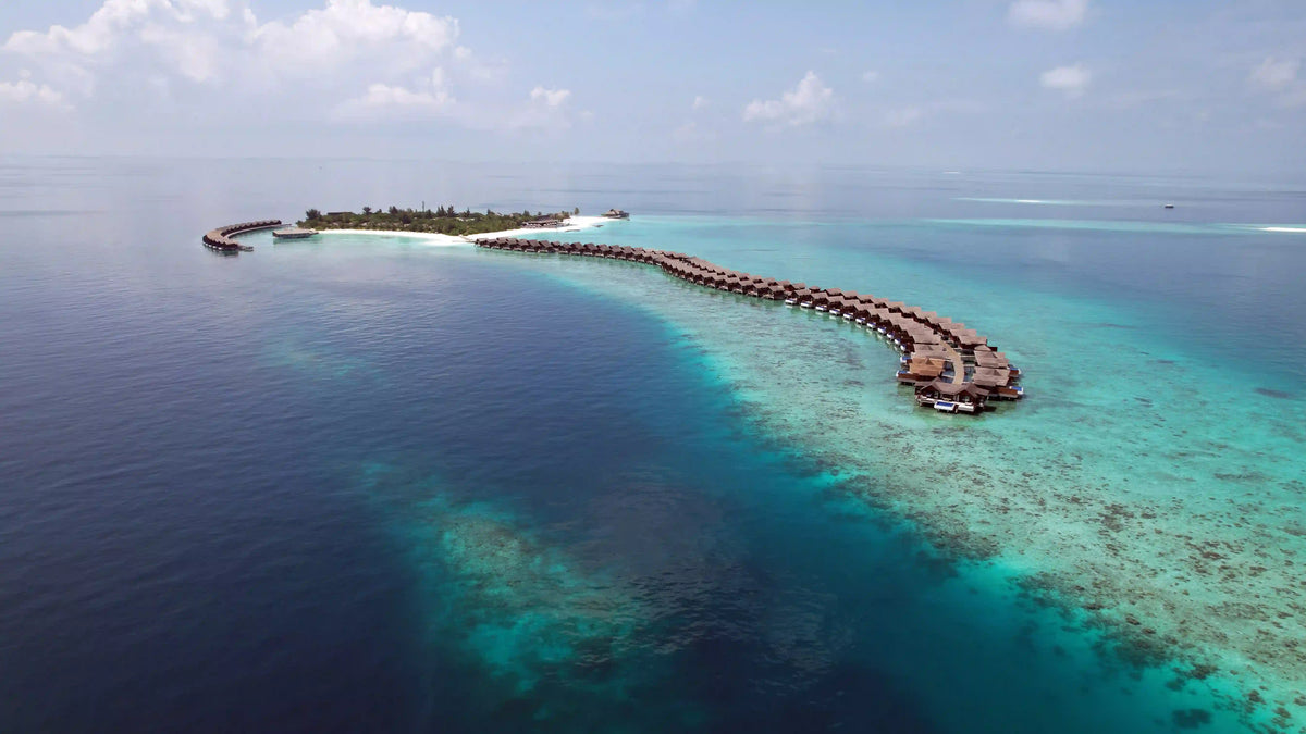 Grand Park Kodhipparu from the air, a jetty of overwater villas reaching out over the reef