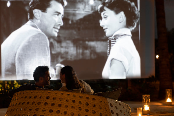 Guests watching a film on the outdoor screen at Huvafen Fushi.