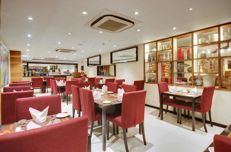 Restaurant at The Somerset Hotel with red chairs and tables laid for dinner