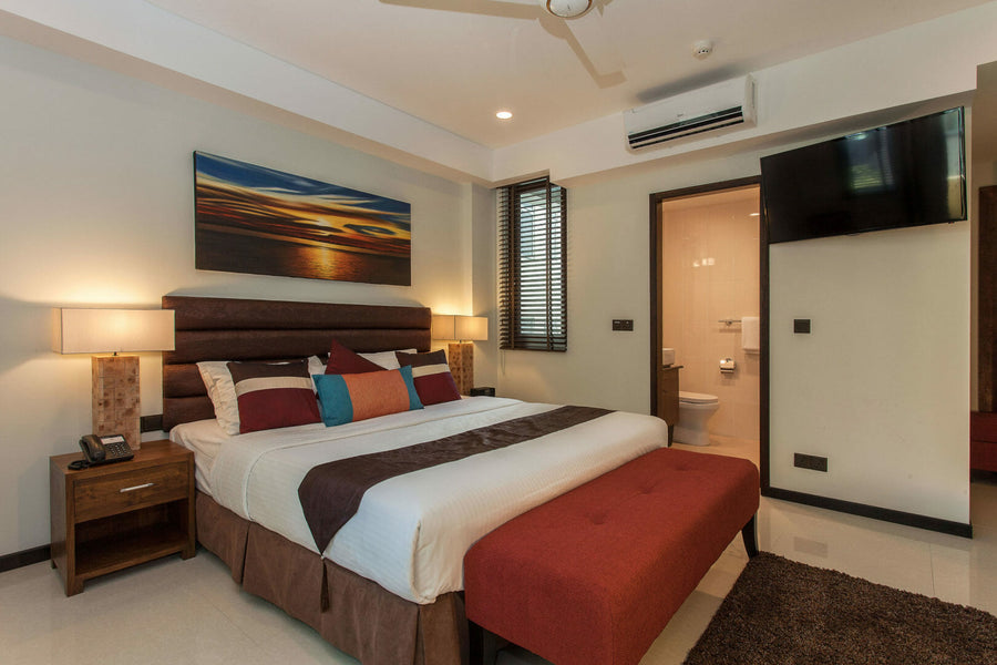 Bedroom at The Somerset Hotel with a red bed runner and wooden furniture
