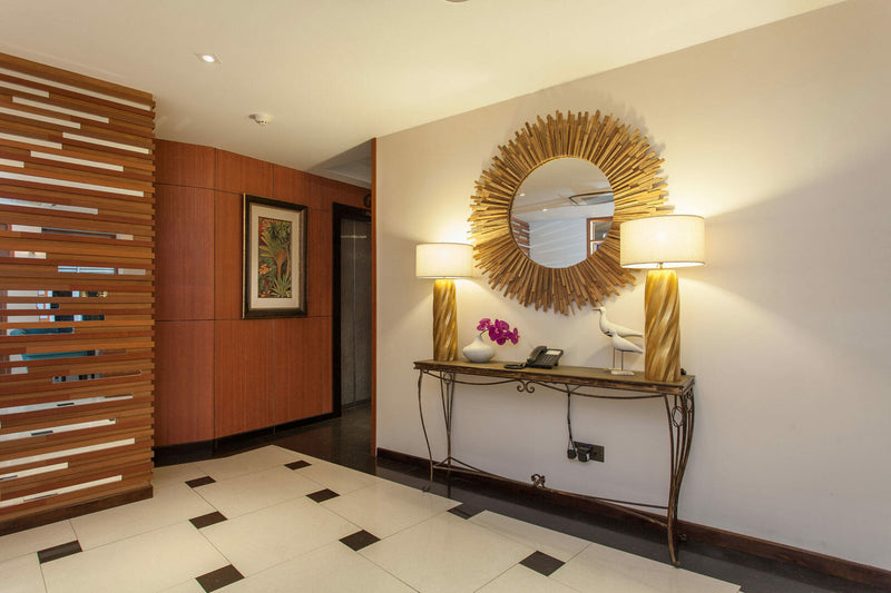 Corridor seating at The Somerset Hotel with a round mirror and console table