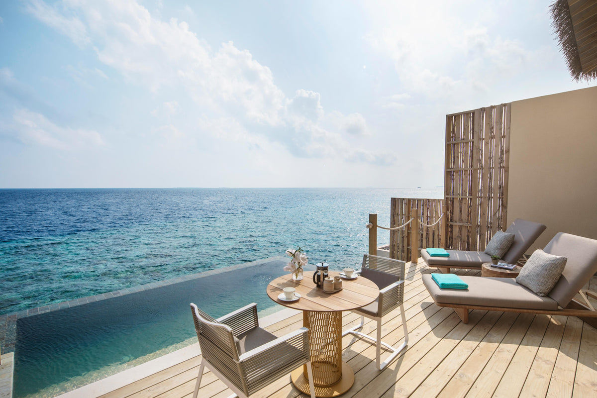 A villa deck at InterContinental Maldives Maamunagau Resort, loungers under a timber screen facing the sea