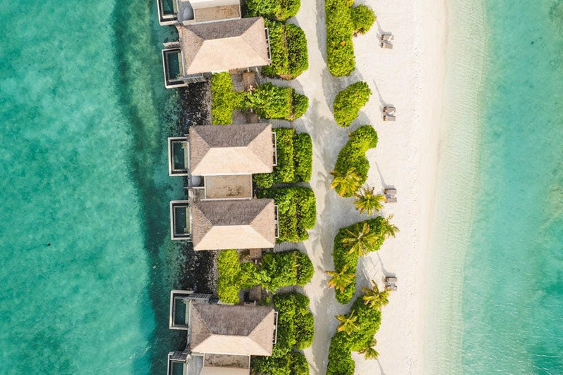 InterContinental Maamunagau from the air, villas behind green hedging along a white sand beach.