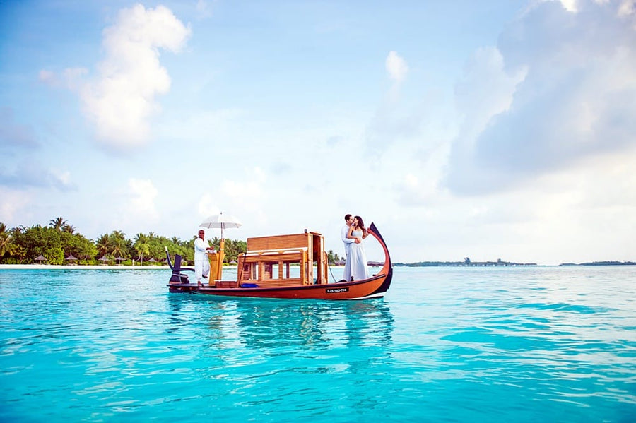 Couple on the bow of a dhoni at sunset, Maldives
