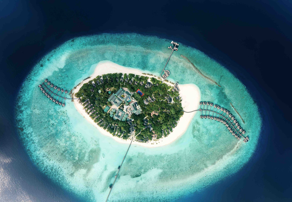 JA Manafaru from the air, the oval island ringed by overwater villas on both sides