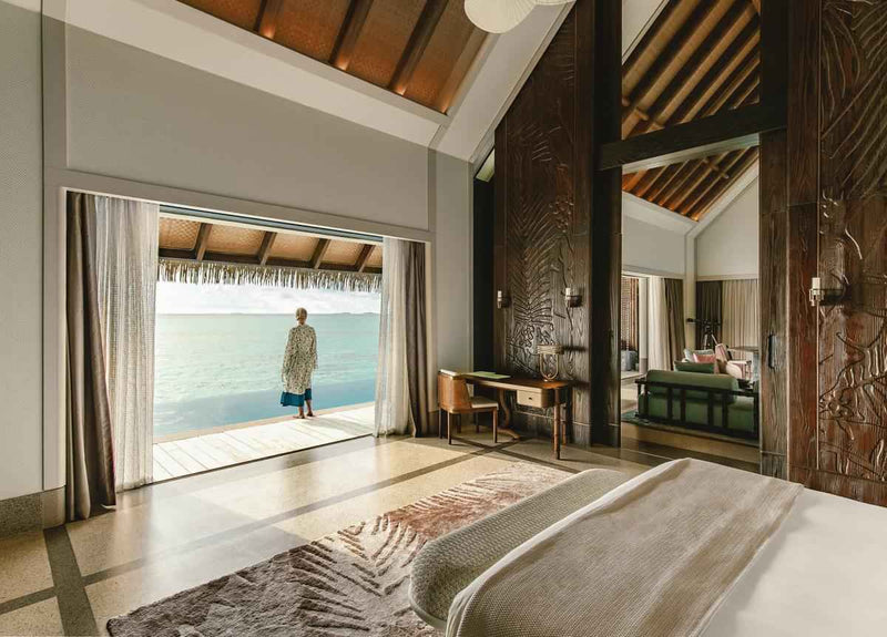 The bedroom of a Luxury Water Villa with Pool at JOALI Maldives, and its view over the lagoon.