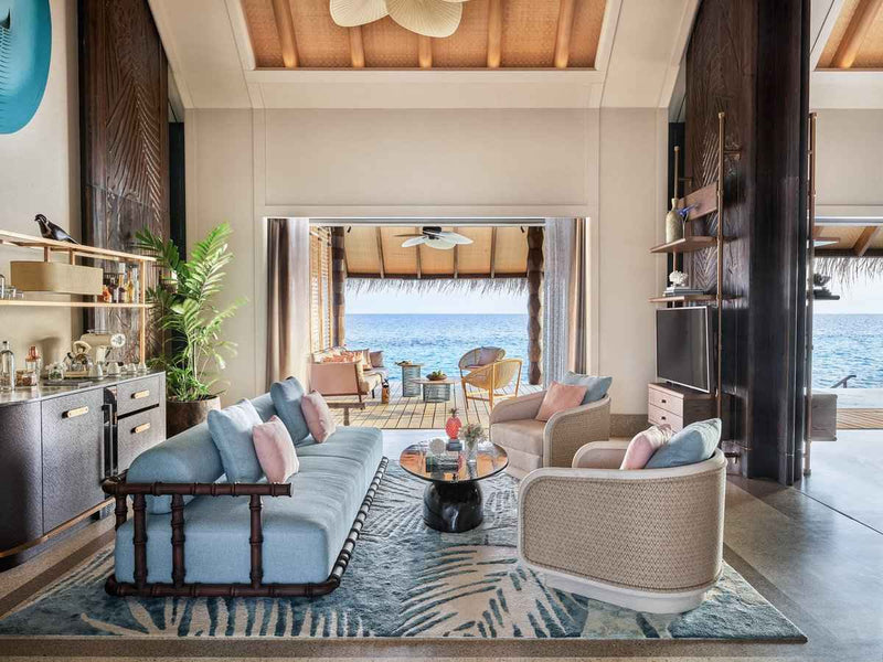 The living room of a Luxury Sunset Water Villa with Pool at JOALI Maldives.