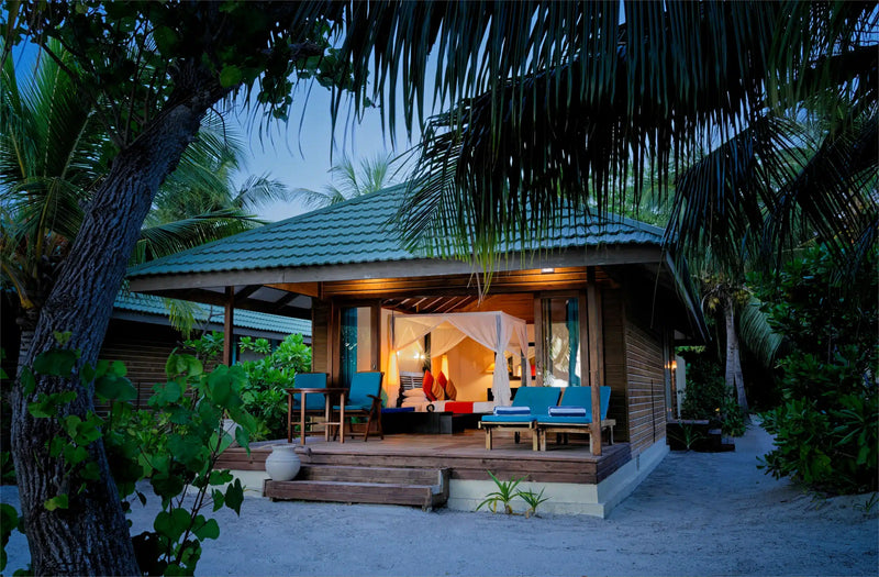 A villa with a private whirlpool at Canareef Resort Maldives, lit after dark